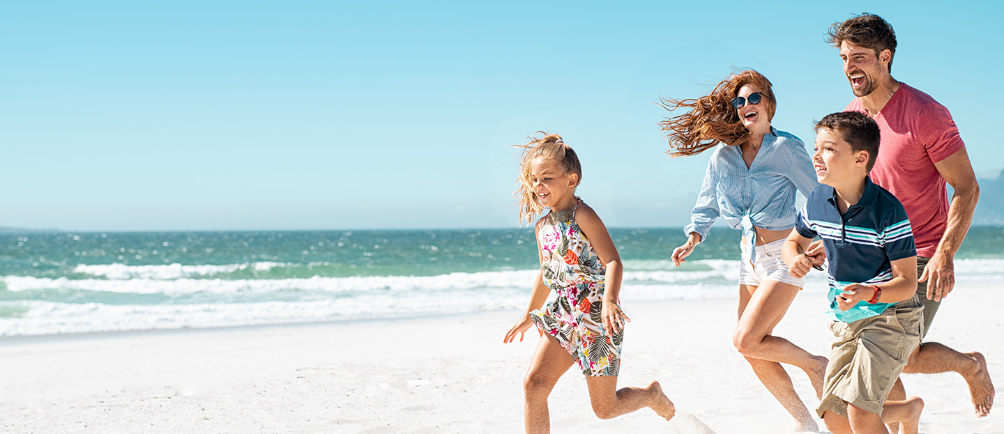 Family running on the beach.